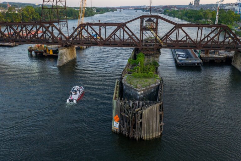 Aerial view of the Avalon Patriot pontoon boat cruising on the Hudson River beneath the Livingston Avenue railroad bridge near Albany and Rensselaer, New York.